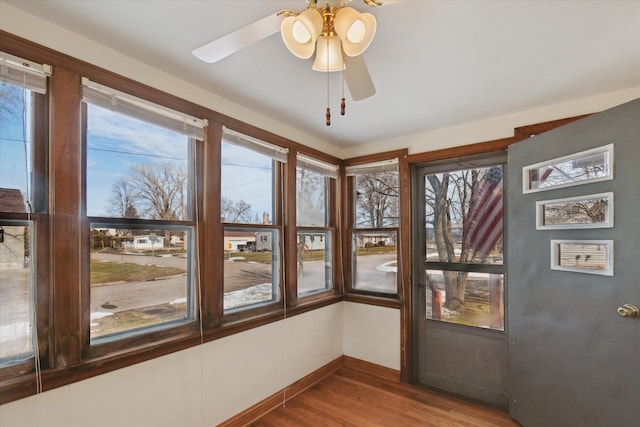 unfurnished sunroom featuring ceiling fan