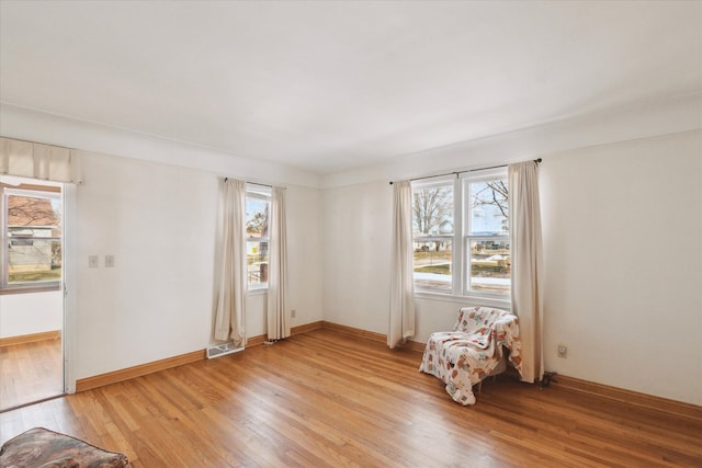 unfurnished room featuring visible vents, light wood-style flooring, and baseboards