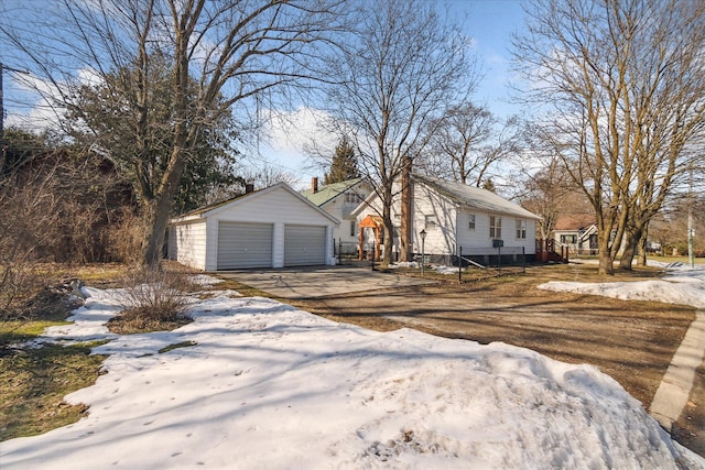 view of front facade with a detached garage and an outbuilding