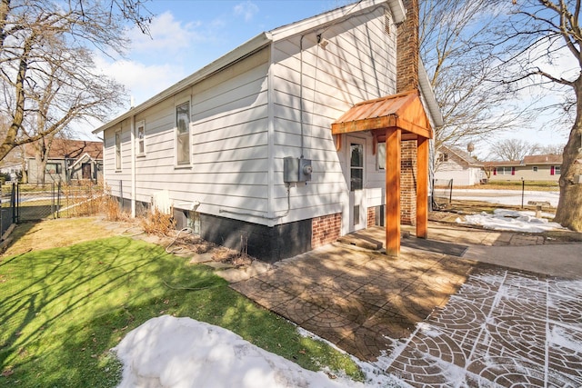 view of property exterior featuring a gate, a chimney, a yard, and fence