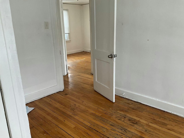 spare room with hardwood / wood-style flooring and baseboards