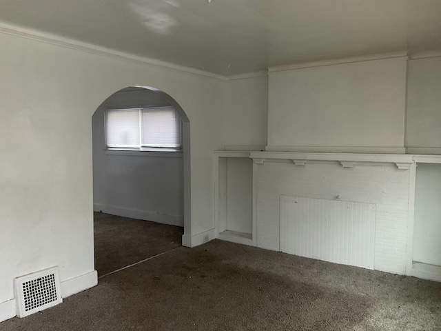 unfurnished living room featuring carpet floors, visible vents, arched walkways, and ornamental molding