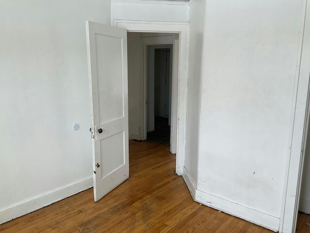 corridor with baseboards and hardwood / wood-style floors