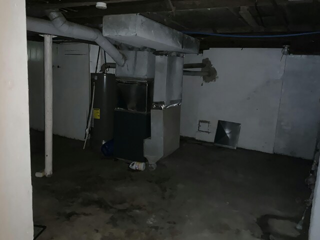 unfinished basement featuring water heater and heating unit