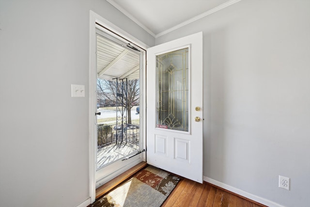 entryway with wood finished floors, baseboards, and ornamental molding