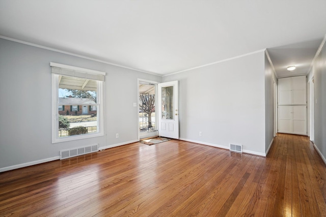 spare room featuring visible vents, baseboards, and hardwood / wood-style flooring