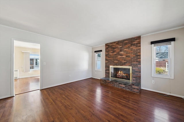 unfurnished living room with a fireplace, wood finished floors, baseboards, and ornamental molding