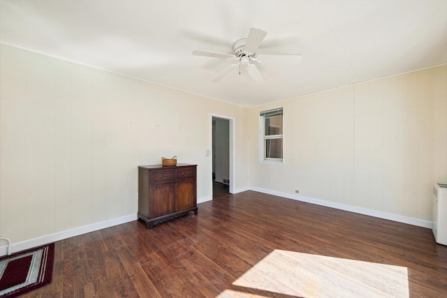 empty room featuring dark wood finished floors, visible vents, baseboards, and ceiling fan