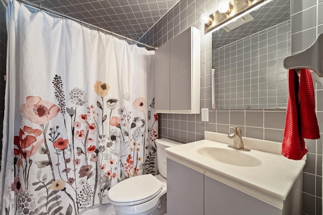 bathroom with vanity, curtained shower, tile walls, toilet, and tasteful backsplash