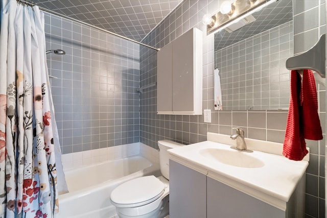 bathroom featuring vanity, decorative backsplash, shower / bath combo with shower curtain, tile walls, and toilet