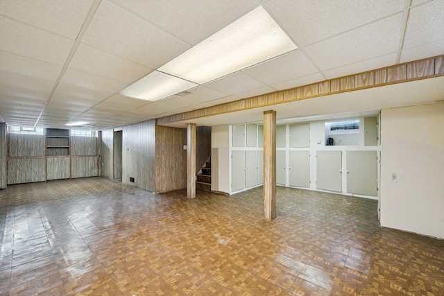 basement featuring stairway and a drop ceiling