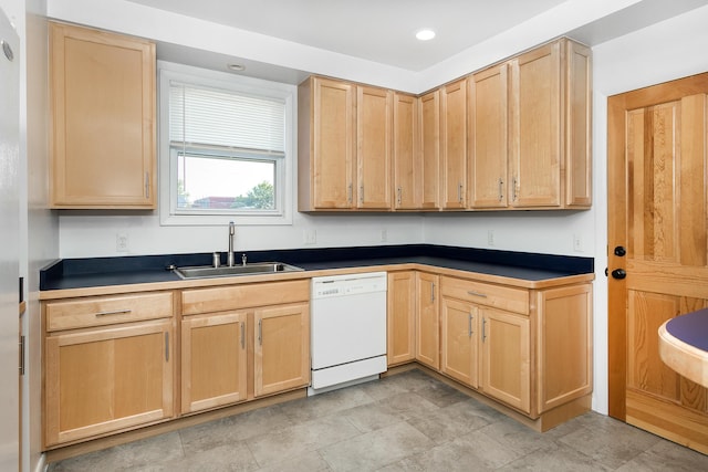 kitchen featuring white dishwasher, light brown cabinets, recessed lighting, a sink, and dark countertops