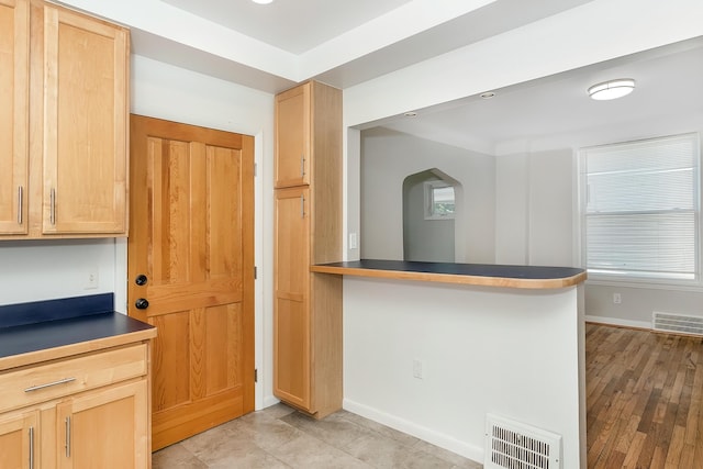 kitchen featuring dark countertops, visible vents, and baseboards