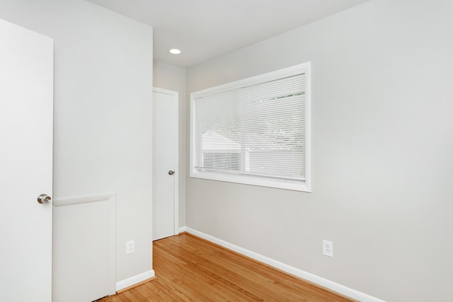 empty room featuring recessed lighting, light wood finished floors, and baseboards