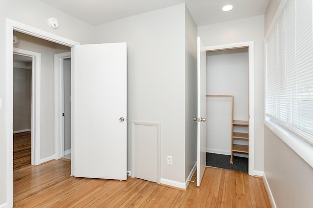 unfurnished bedroom featuring light wood-style flooring and baseboards