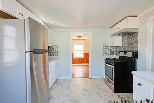 kitchen with under cabinet range hood, tasteful backsplash, appliances with stainless steel finishes, and white cabinets