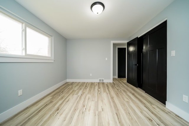 unfurnished bedroom featuring light wood-type flooring, visible vents, and baseboards