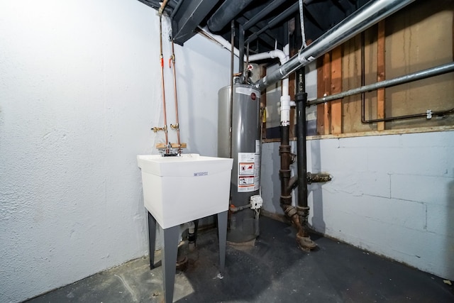 utility room featuring gas water heater and a sink