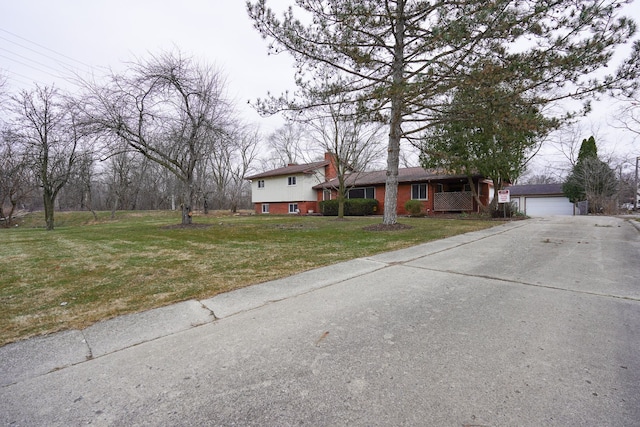 view of front of property with an outbuilding, brick siding, a chimney, a garage, and a front lawn