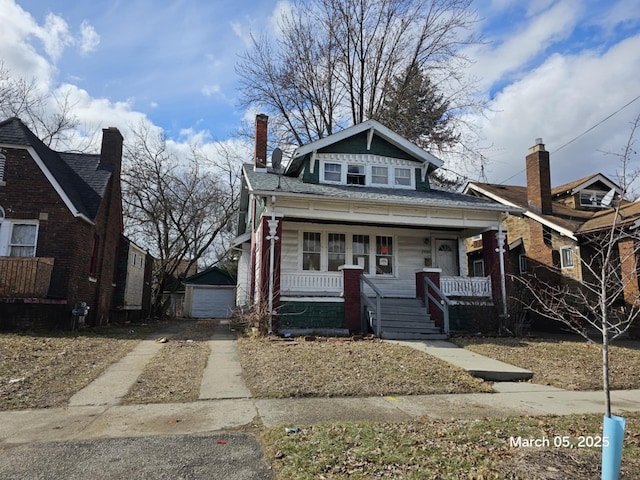 bungalow featuring a garage, an outbuilding, covered porch, and driveway