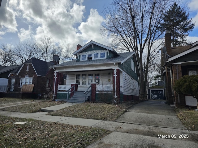 bungalow-style home with a porch and an outbuilding