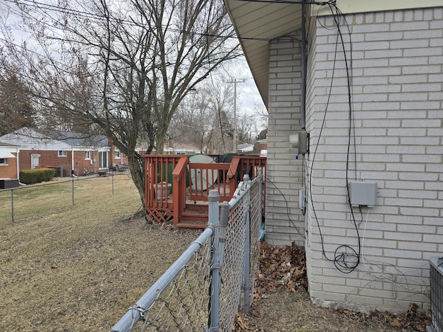 view of home's exterior featuring brick siding, fence, and a wooden deck