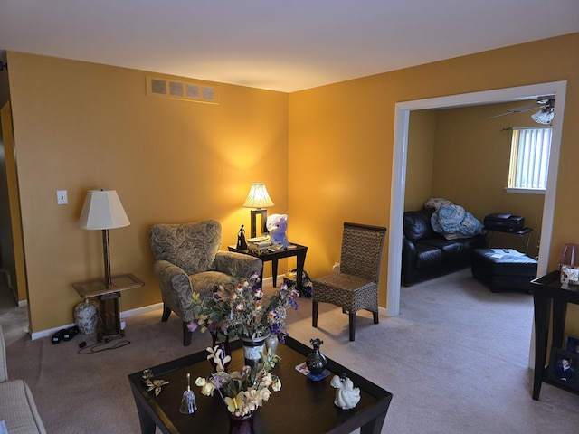 carpeted living area featuring visible vents and baseboards