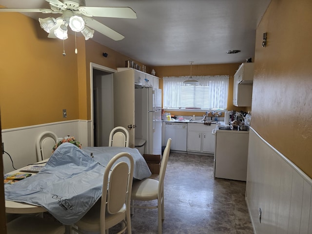 kitchen featuring ceiling fan, white appliances, white cabinetry, wainscoting, and decorative light fixtures