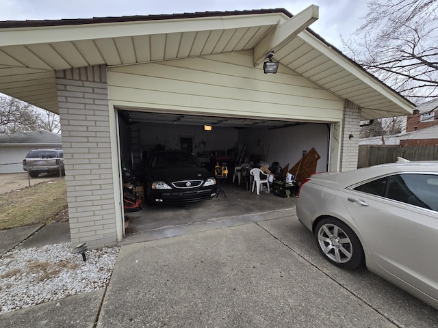 garage featuring fence and driveway