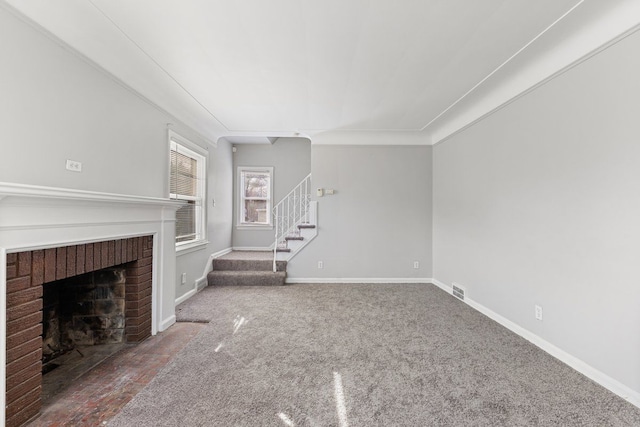 unfurnished living room with visible vents, carpet, baseboards, stairs, and a fireplace