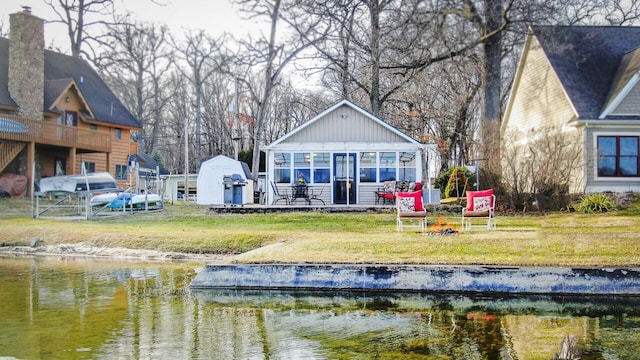 rear view of house with a lawn and a water view