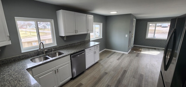 kitchen with freestanding refrigerator, white cabinets, a sink, and dishwasher