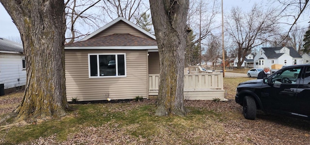 view of side of home with a shingled roof and a residential view