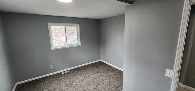 empty room with visible vents, baseboards, and dark colored carpet