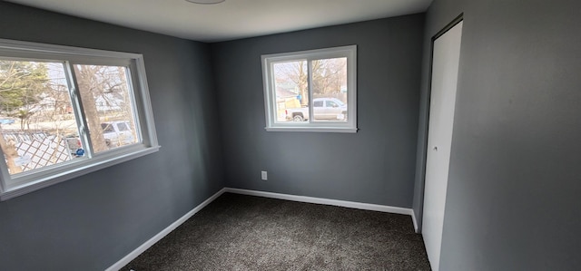 carpeted empty room with baseboards