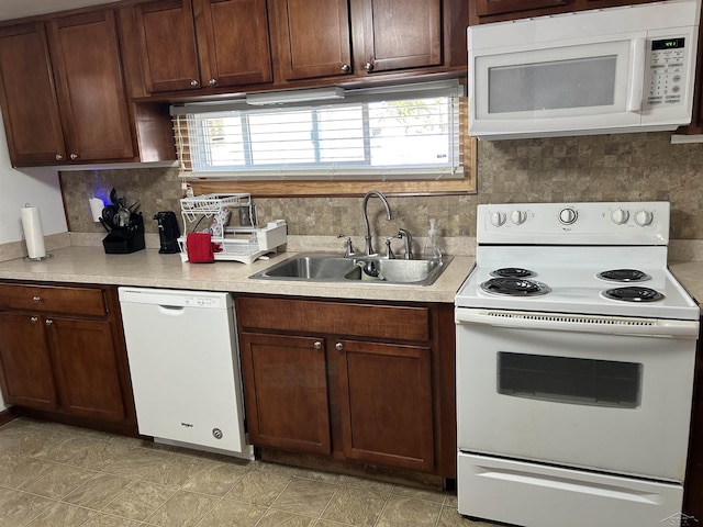 kitchen featuring a sink, decorative backsplash, white appliances, and light countertops