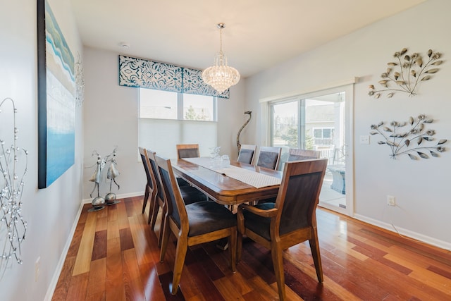 dining area featuring a chandelier, baseboards, and hardwood / wood-style floors