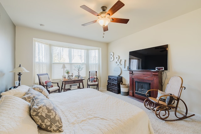 carpeted bedroom with a ceiling fan, a fireplace, and baseboards