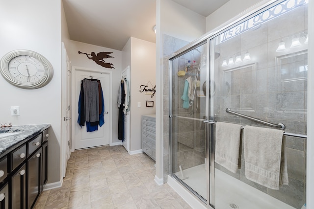 bathroom with vanity, baseboards, and a stall shower