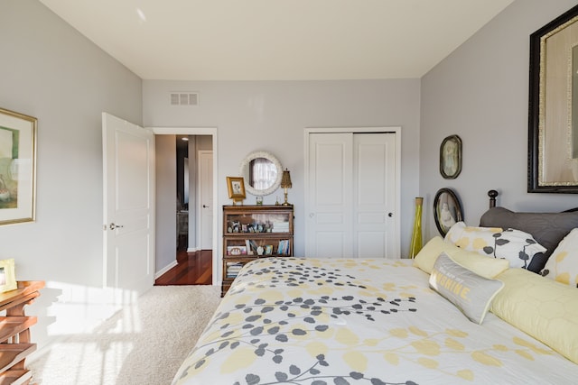 carpeted bedroom featuring visible vents and a closet