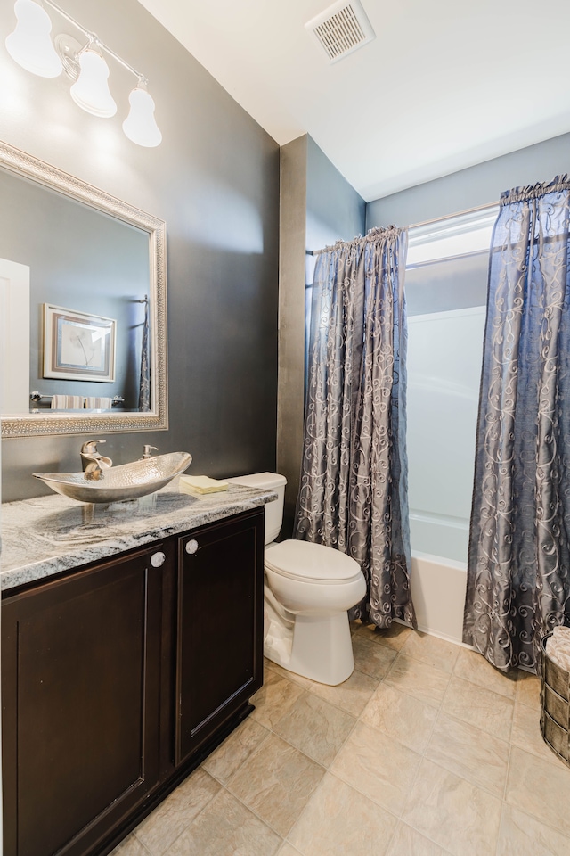 bathroom with vanity, shower / tub combo, toilet, and visible vents