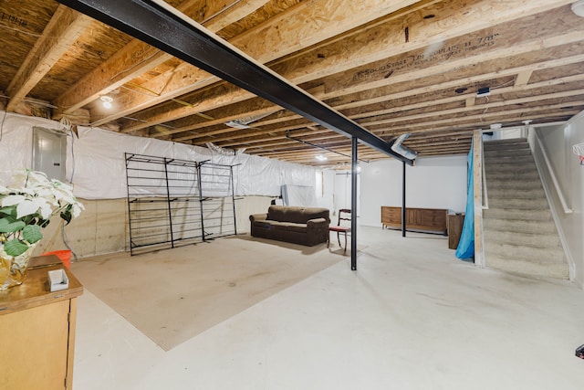 unfinished basement with electric panel and stairway