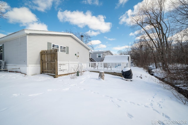 snow covered rear of property featuring a wooden deck