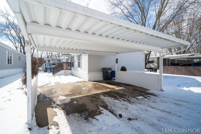 snow covered patio with a detached carport