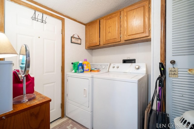 clothes washing area featuring cabinet space, a textured ceiling, and separate washer and dryer