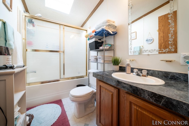 bathroom with vaulted ceiling with skylight, combined bath / shower with glass door, vanity, and toilet