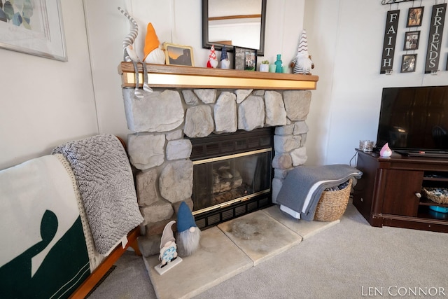 living area featuring carpet and a fireplace