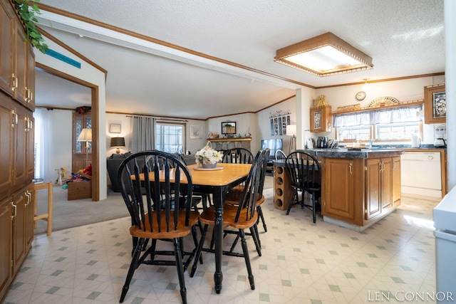 dining space featuring light floors, ornamental molding, and a textured ceiling