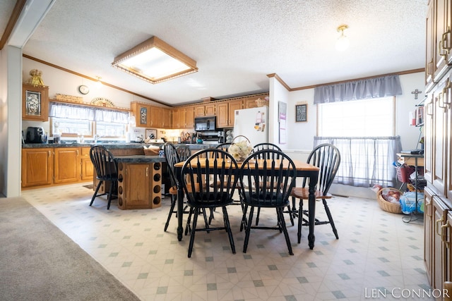 dining space with a textured ceiling, vaulted ceiling, and crown molding