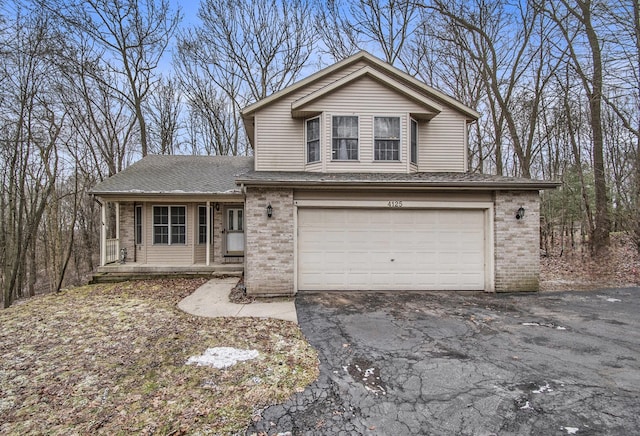 view of front of property featuring brick siding, a porch, a shingled roof, an attached garage, and driveway